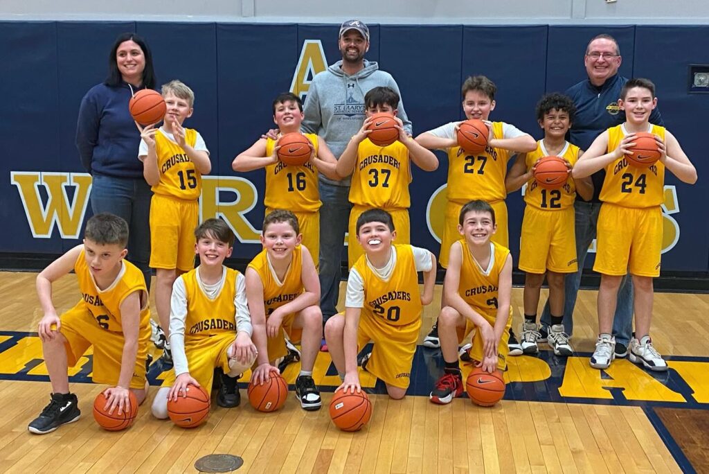 Youth basketball team in school gym wearing Crusaders uniforms