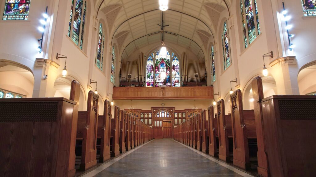 Interior of a church with wooden pews and stained glass windows